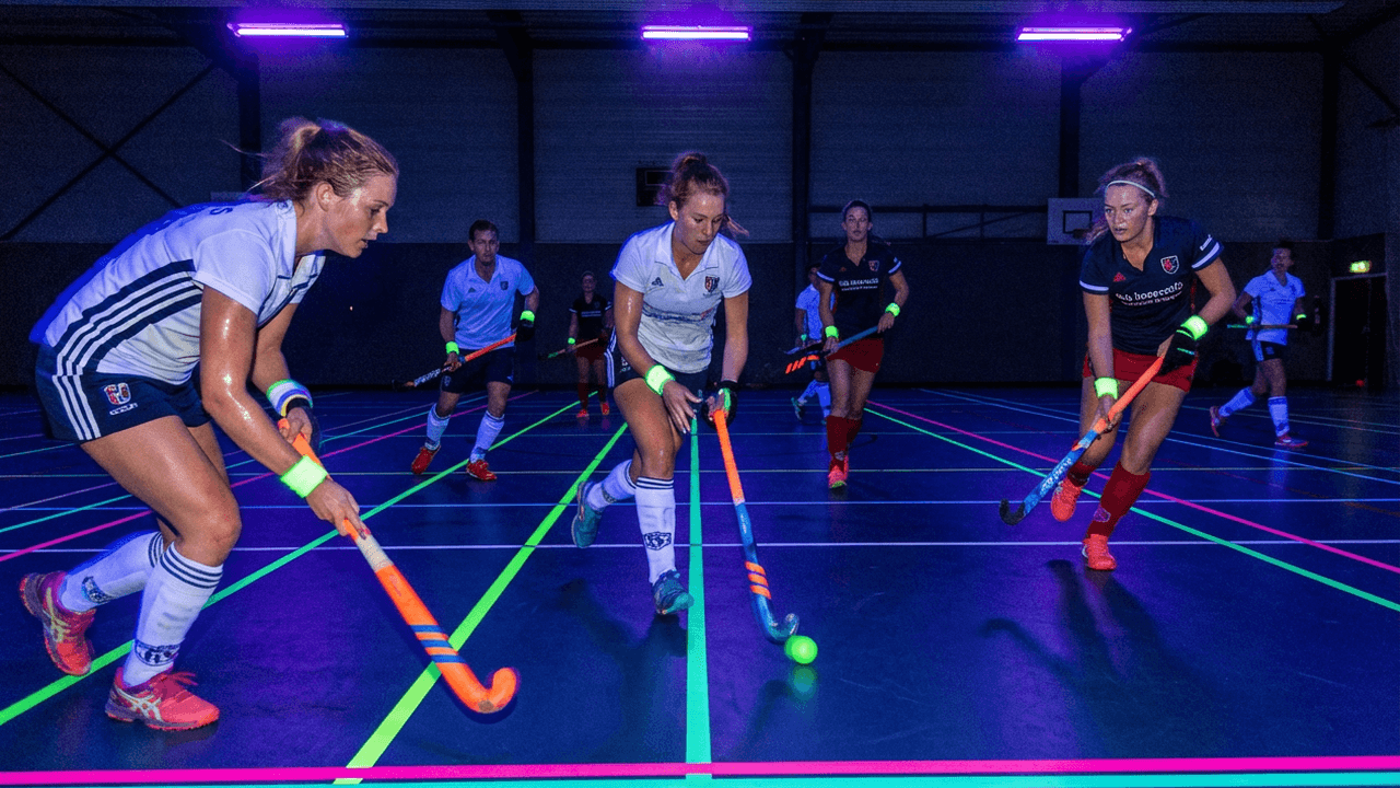 Glow in de dark zaalhockey in een sporthal