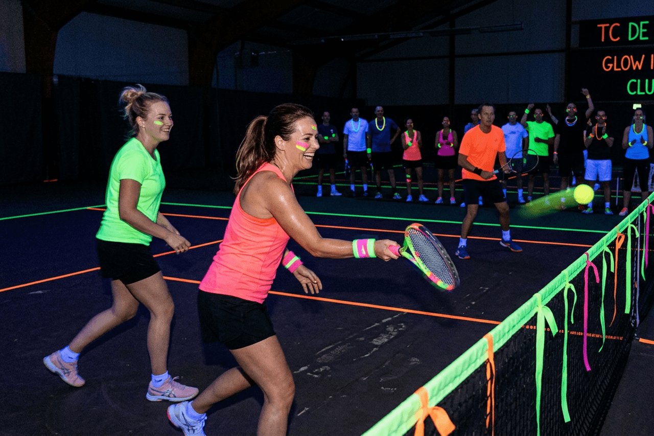 Glow in the dark tennis in een sporthal met UV-verlichting en neonlijnen