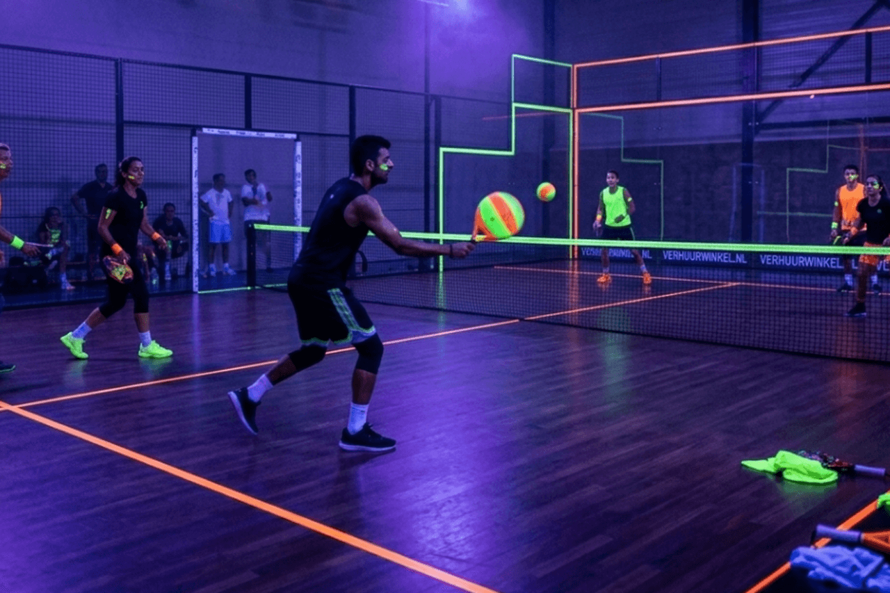 Glow in the dark padel met UV-verlichting en neonlijnen op de baan