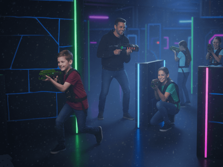 Een groep blije kinderen en een volwassen man spelen lasergame in een donkere arena met neonverlichting.